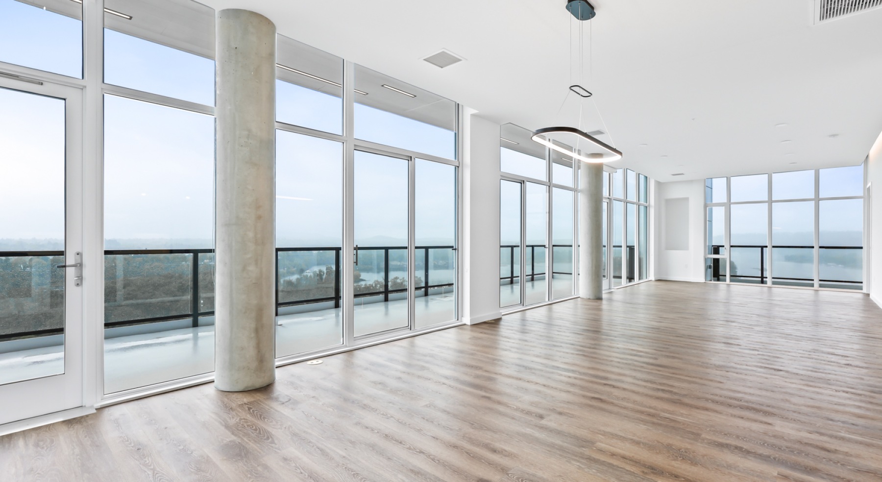 an empty living room with wood floors and windows