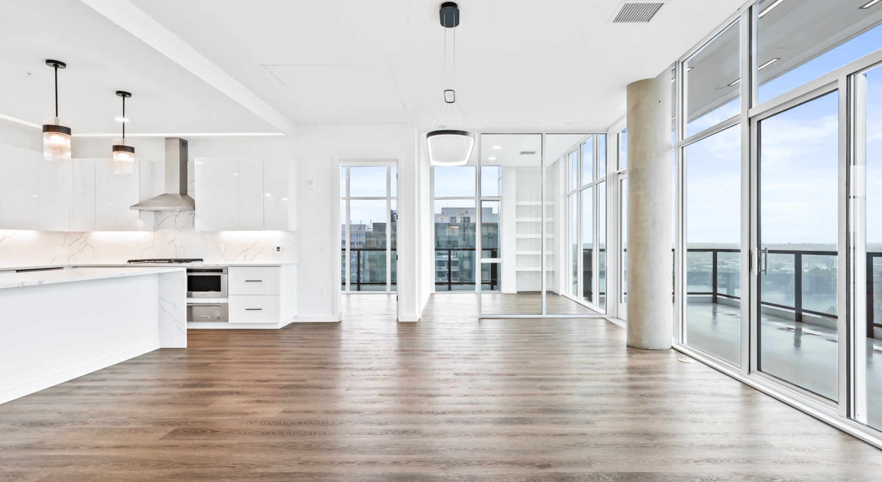 an empty living room with wood floors and windows